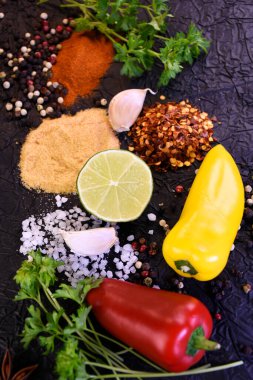 Yemek pişirmek için çeşni. Biber, tuz, sarımsak, siyah arka planda maydanoz.