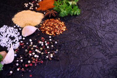 Yemek pişirmek için çeşni. Biber, tuz, sarımsak, siyah arka planda maydanoz.