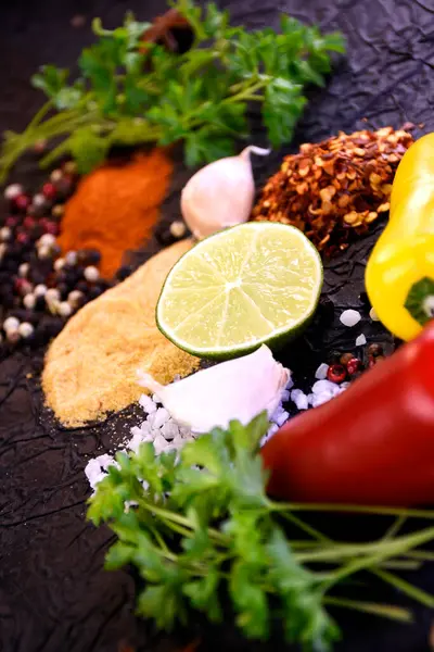 Yemek pişirmek için çeşni. Biber, tuz, sarımsak, siyah arka planda maydanoz.