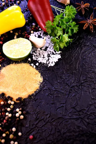 Yemek pişirmek için çeşni. Biber, tuz, sarımsak, siyah arka planda maydanoz.