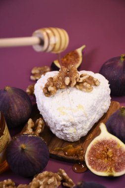 Süzme peynirli incir ve mor arka planda bal. Akdeniz mutfağı