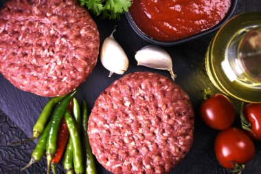 Hamburger yapmak için malzemeler. Baharatlı taze et. taze sebze.