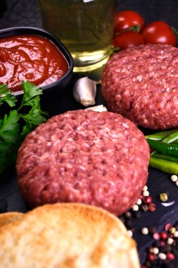 Hamburger yapmak için malzemeler. Baharatlı taze et. taze sebze.