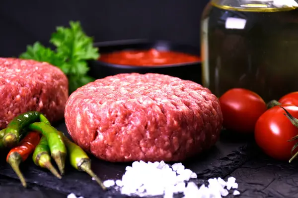 Hamburger yapmak için malzemeler. Baharatlı taze et. taze sebze.