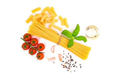 İtalyan yemeklerini hazırlamak için malzemelerle birlikte beyaz bir arka planda mutfak kompozisyonu. Çeri domates, çiğ makarna (spagetti ve rigatoni), taze fesleğen yaprağı, sarımsak karanfili, zemin ve tam biber karışımı..