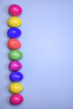 Mavi arka planda tek sıra halinde Paskalya yumurtaları..