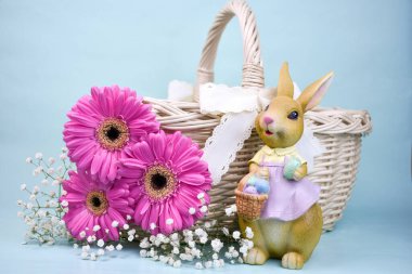 Paskalya kompozisyonu, üzerinde leylak rengi bir elbise giymiş tavşan figürü yanında hasır bir sepetin yanında dantel kurdeleyle süslenmiş yumurta sepeti tutuyordu. Kompozisyonda parlak pembe gerberalar ve beyaz gypthe çiçekleri de yer almaktadır. 