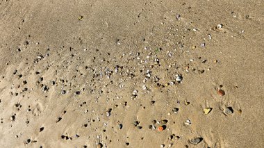 Ve kum ve çakıl taşlarının arka planında doğal rahatlama şekilleri oluşacak olan rüzgar olacak. Altın deniz kum dokusu, kumlu yüzey.