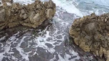 Küçük deniz dalgaları kayalara çarpıyor..