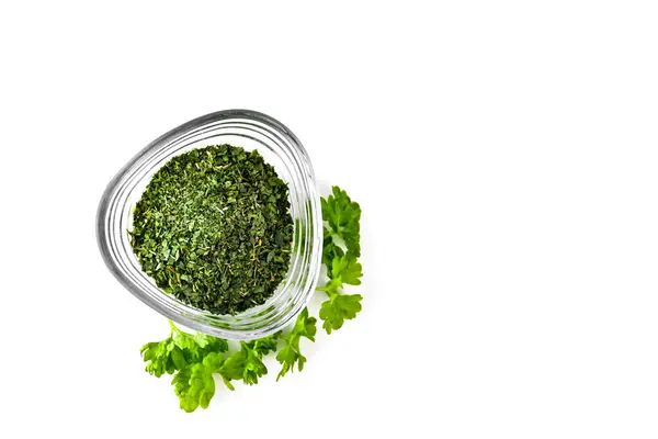 Beyaz arka planda cam bir kasede taze ve kurutulmuş maydanoz..