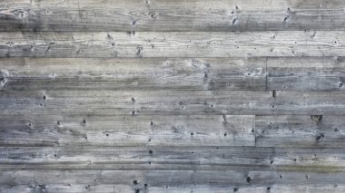 Çatlaklarla, düğümlerle ve zaman izleriyle kaplı eski tahtaların ahşap dokusu.