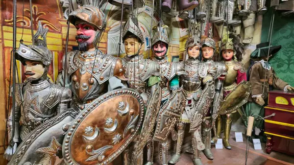 Şövalye zırhı içindeki geleneksel Sicilya kuklaları, metal kalkanlar ve kılıçlarla süslenmiş, bir tiyatro veya müzede sergileniyor..
