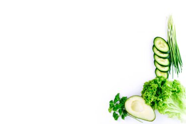 Beyaz arka planda taze sebze, ot ve avokado minimalist bileşimi. Sağlıklı yeme, diyet, detoks ürünleri ve organik gıda kavramı.