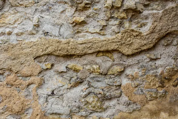 Eski alçı kalıntılarıyla taştan sert bir duvar..