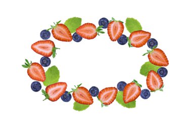 Taze çilek yarımları, yaban mersini ve nane yaprakları beyaz arka planda oval biçimde dizilmiş. Fotokopi alanı olan sağlıklı yaz meyve çerçevesi.