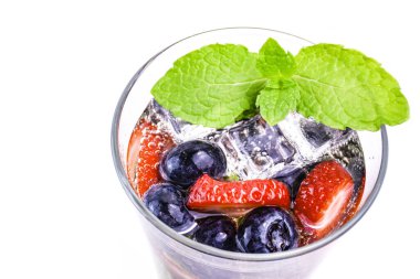 Meyveli soda, böğürtlen, buz ve beyaz arka planda bir bardak nane şekeri. Taze yaz içeceği, üst manzara..