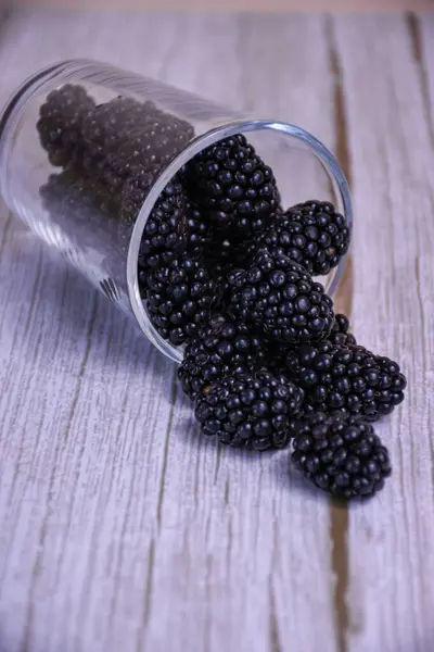 Taze böğürtlenler ahşap zemin üzerine dökülür.