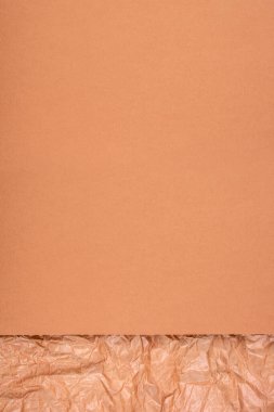 Yumuşak ve buruşuk kağıtların sıcak tonlarda kombinasyonu ile minimal arkaplan.