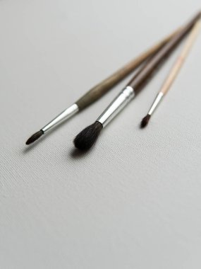 Beyaz tuval arka planda siyah kollu ahşap boya fırçası.