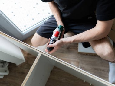 Mobilya montajı el kitabı. İşçi Okuma Talimatları Kabinesi Ev Yenilemesi Yapıyor. Yüksek kalite fotoğraf