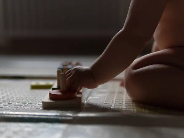 stock image Child plays with plastic toy baby sorter with geometric figures. Top view. High quality FullHD footage