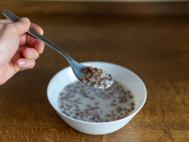 Beyaz bir kasede muz ve kahvaltıda sütlü koyu çikolatalı ev yapımı granola. Kahvaltı gevreği. Yüksek kalite fotoğraf