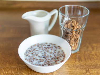 Beyaz bir kasede muz ve kahvaltıda sütlü koyu çikolatalı ev yapımı granola. Kahvaltı gevreği. Yüksek kalite fotoğraf