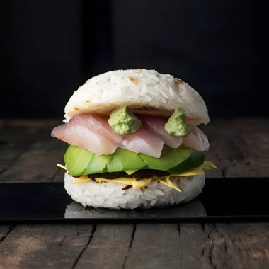 Hamburger ve suşi. İçinde pirinç ekmeği, avokado, çiğ balık ve wasabi var.