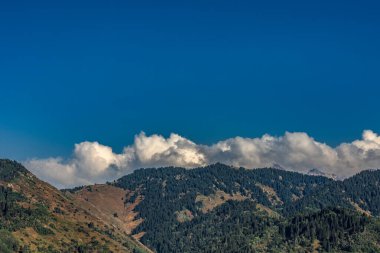 Bulutları ve mavi gökyüzü olan güzel dağ manzarası