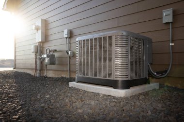 Modern HVAC air conditioner unit on concrete slab outside of duplex house. clipart