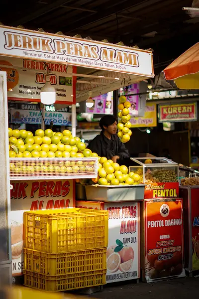 stock image A man is waiting for buyers at his orange juice shop in the afternoon