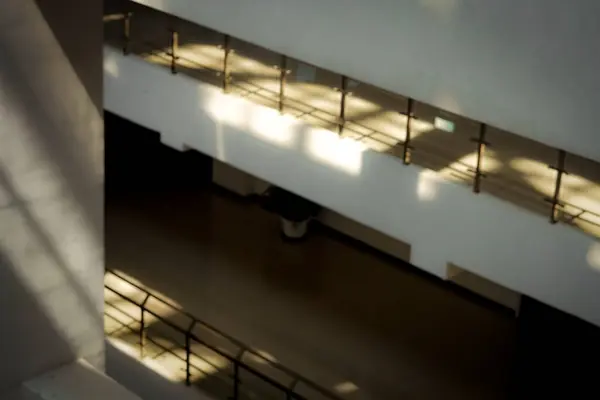 Sessiz minimalist, beyaz, çok katlı bina gündüz gözlüklü çatıdan parlak bir ışık alıyor.