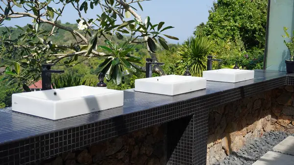 Okyanus ve tepeler manzaralı minimalist modern bir lavabo.