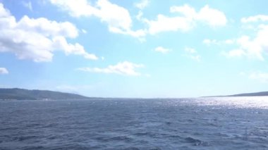 Açık okyanus, berrak gökyüzü ve beyaz bulutlar sessiz bir sabahta