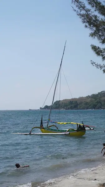 Gün boyunca Pasir Putih Situbondo sahilinde geleneksel bir tekne.