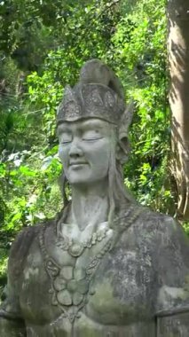 Bir Endonezya hikayesinden kalma dev bir tanrı ya da tanrıça heykeli. Sinema filminde Kemesraan Park, Pujon, Batu Malang 'daki yeşil ağaçların arka planına sahip.