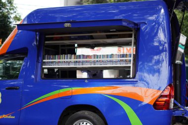 Bookshelves inside the mobile library car in the middle of Malang city clipart