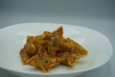 Beyaz bir tabakta kızarmış hamur köftesi.