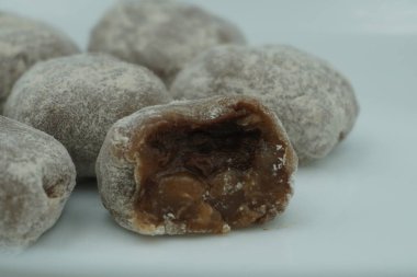 Çikolata dolgulu ve beyaz arkaplanlı beyaz tozlu Mochi.