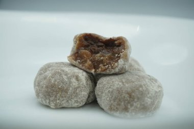 Çikolata dolgulu ve beyaz arkaplanlı beyaz tozlu Mochi.