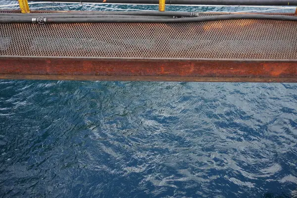 Demir köprü ve deniz suyu üzerinde sarı korkuluklar.