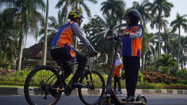 Malang Arabasız Günü 'nü denetleyen ulaşım hizmeti memurları elektrikli scooter ve bisiklet kullanıyorlar.