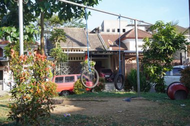 Boş bahçe, öğleden sonra güneşe maruz kalan kullanılmış lastiklerden yapılmış salıncaklar.