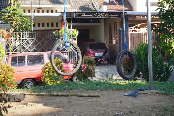 stock image Empty garden with swings made of used tires exposed to the sun in the afternoon