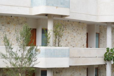 Bali 'de beyazlar içinde modern minimalist tarzı olan çok katlı bir otel binası.