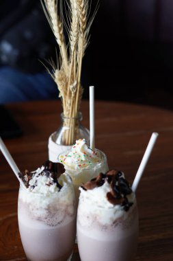 Soğuk çikolata ve krem şantili vanilyalı milkshake, mısır gevreği ve pipet.