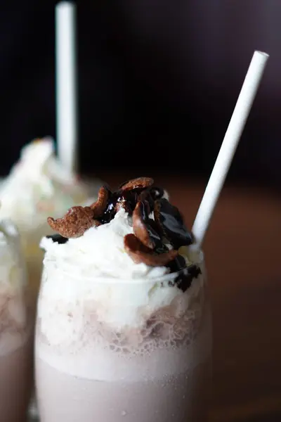 Soğuk çikolata ve krem şantili vanilyalı milkshake, mısır gevreği ve pipet.