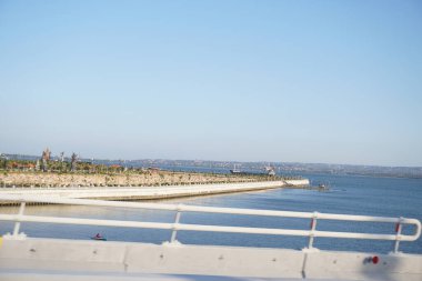 Sea view and tourist attractions from Bali Mandara toll road in the afternoon clipart