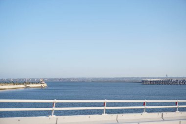 Sea view and tourist attractions from Bali Mandara toll road in the afternoon clipart