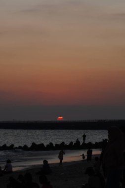 Kelan Beach, Bali 'ye gelen ziyaretçilerin silueti, öğleden sonra gün batımını bekliyor.